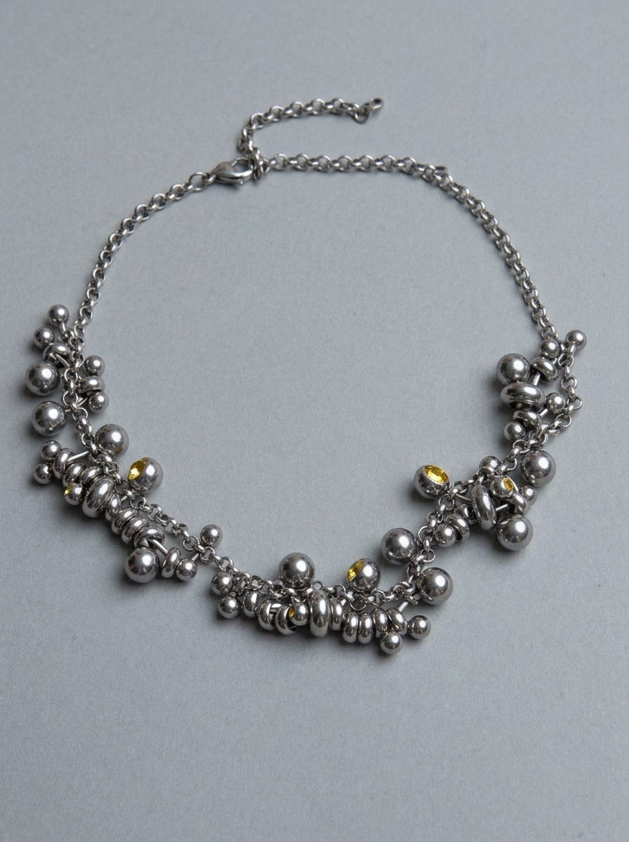 Silver beaded necklace on a gray background