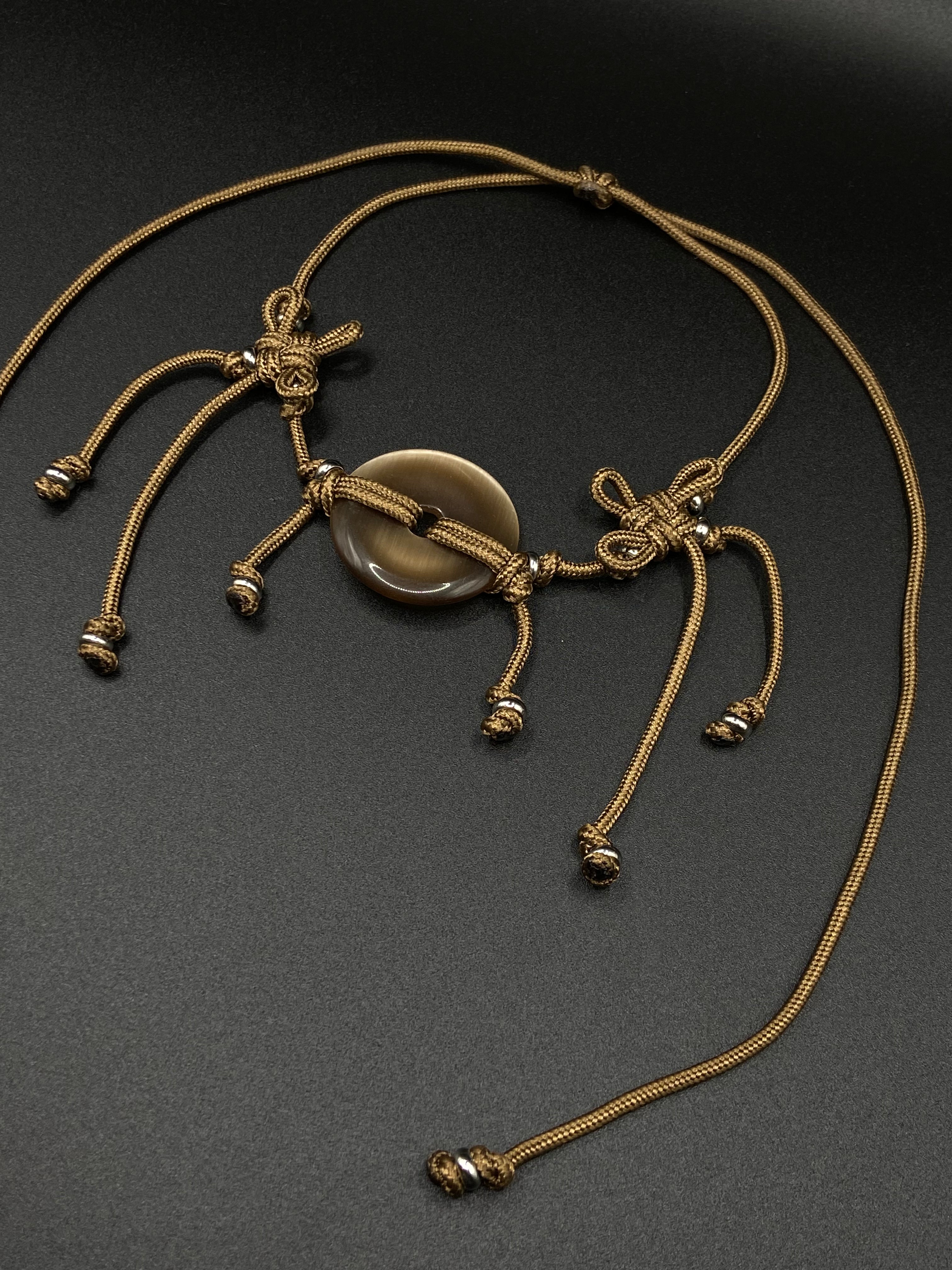 Gold necklace with a central stone on a dark background