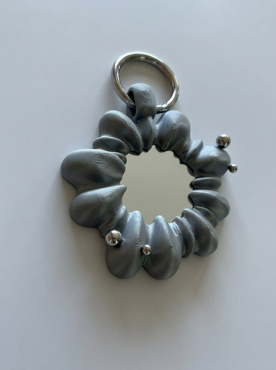 Gray scrunchie keychain with silver beads on a white background