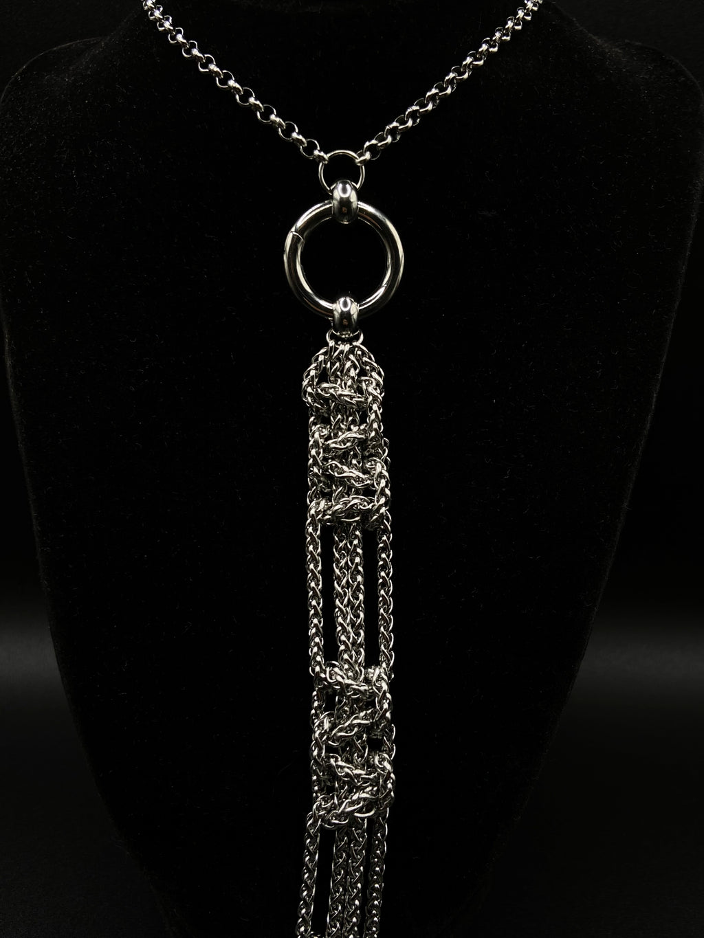 Silver necklace with a detailed pendant on a black background