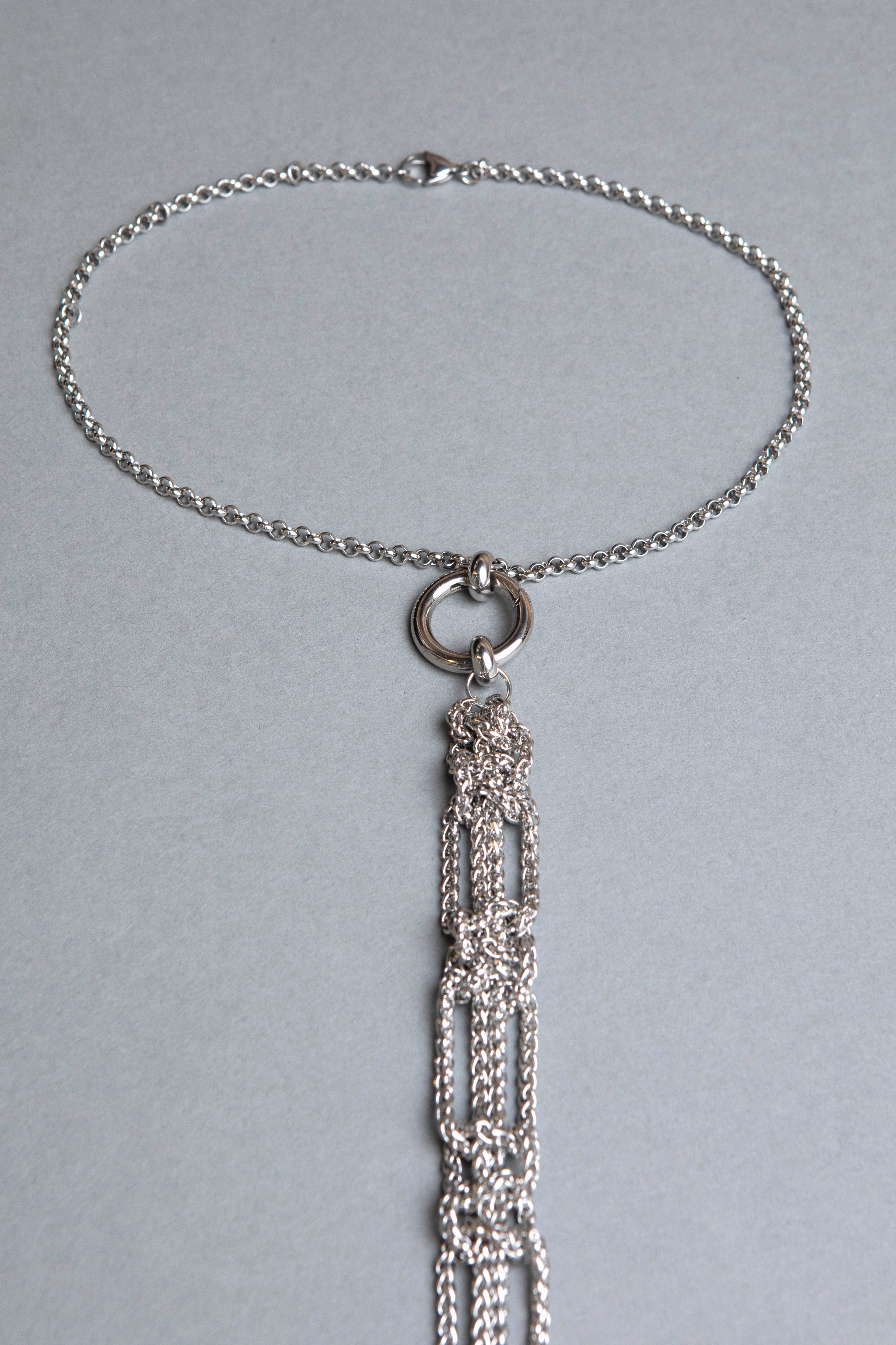 Silver necklace with a decorative pendant on a gray background