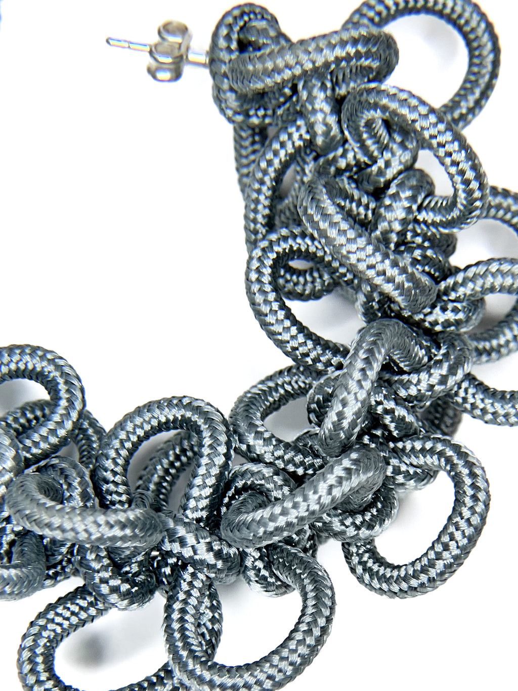Close-up of braided silver cord on a white background